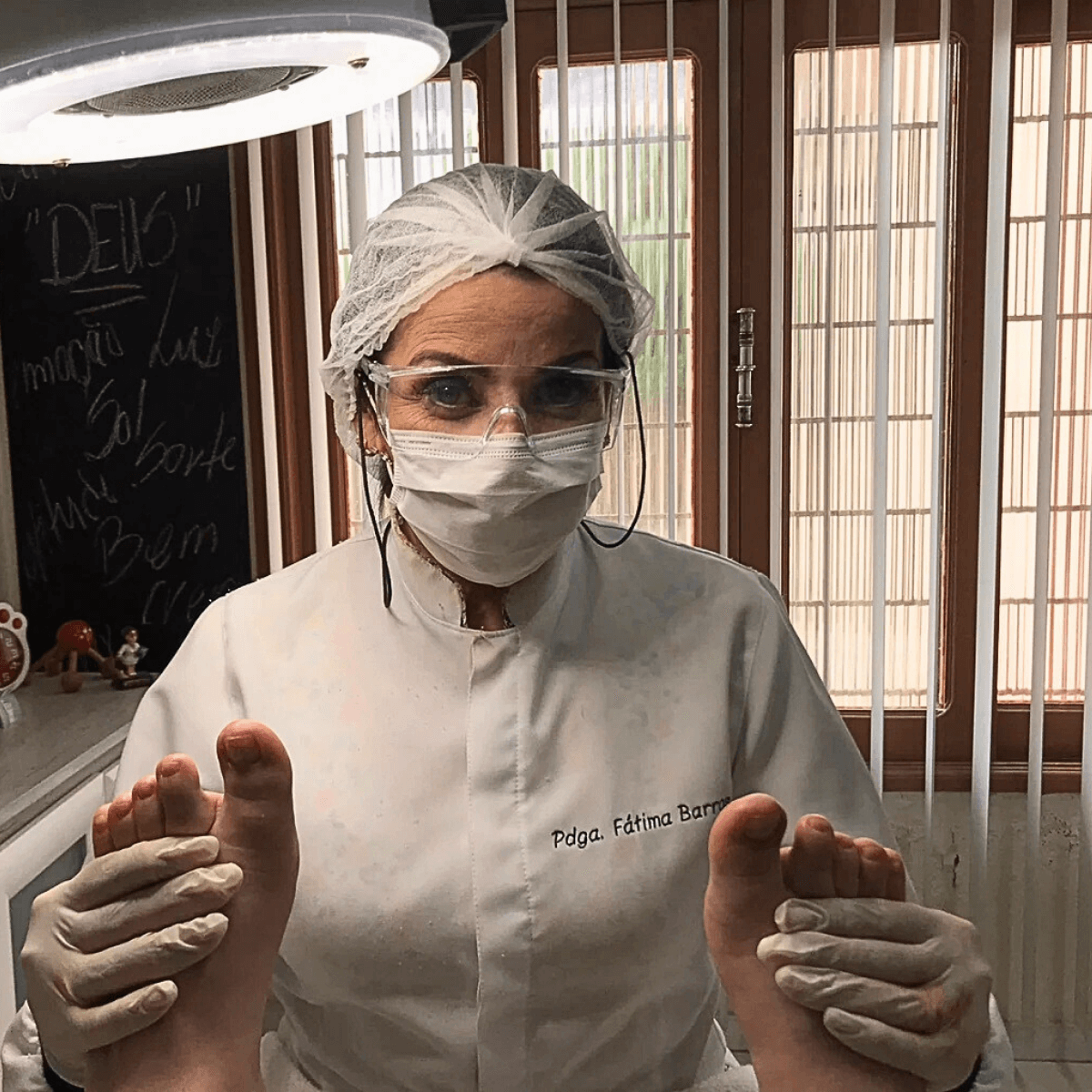 Podóloga Fátima Barros sorrindo em sua mesa de atendimento